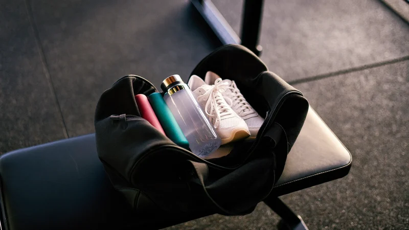 Sac ouvert et rangé avec serviette, gourde, baskets et bandes élastiques